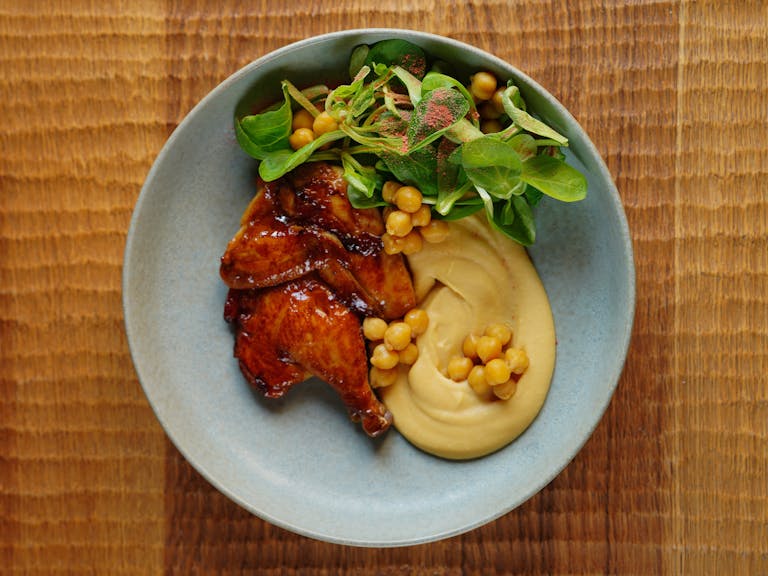 Tantalizing roast chicken paired with creamy hummus and fresh green salad.