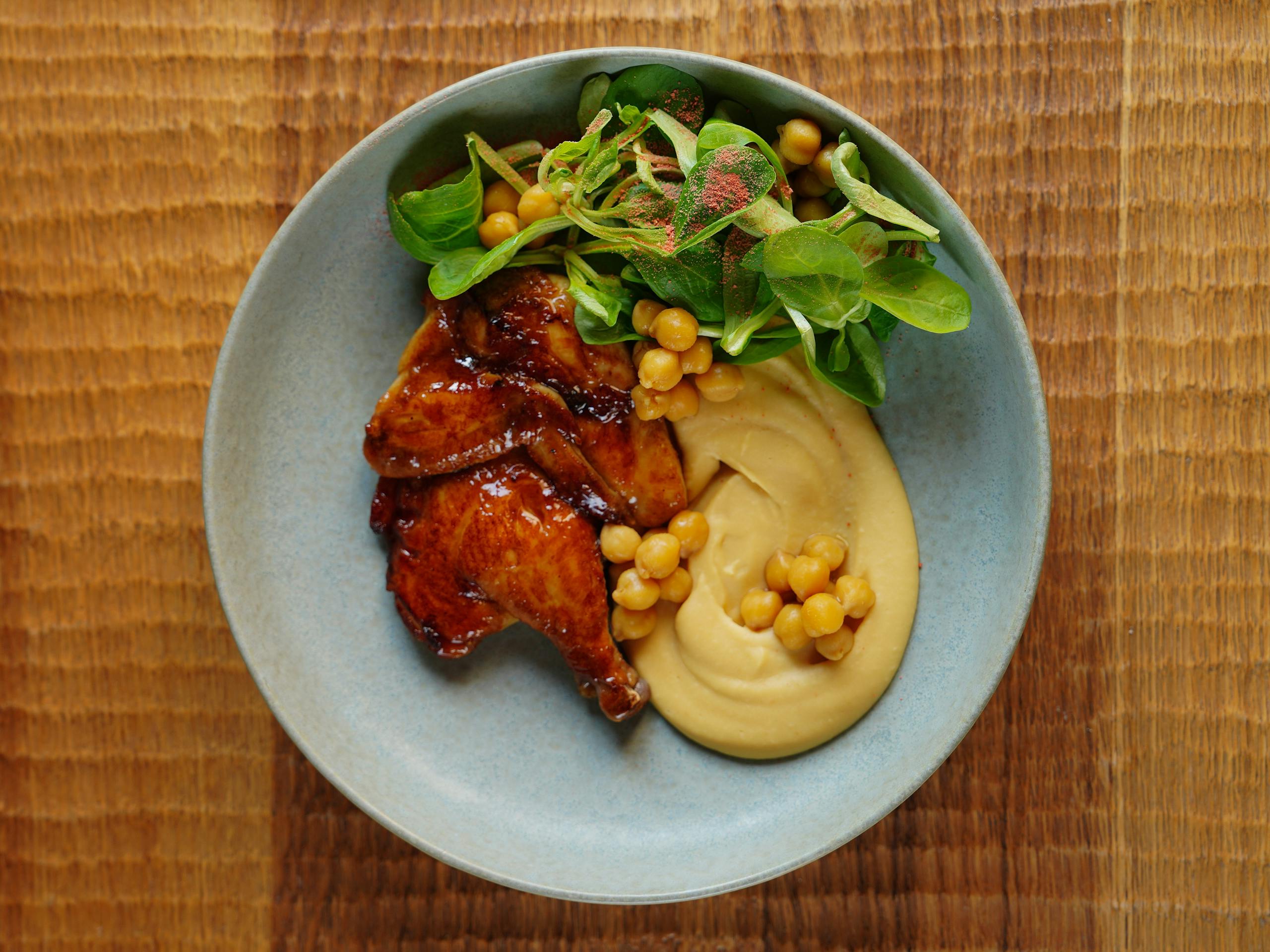 Tantalizing roast chicken paired with creamy hummus and fresh green salad.